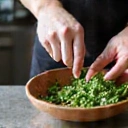 A chef's hand mixing fresh ingredients in a bowl, symbolizing customized recipes.